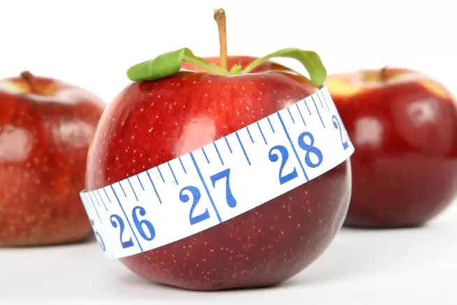 Dieta ciclica Mela in primo piano avvolta da un centimetro