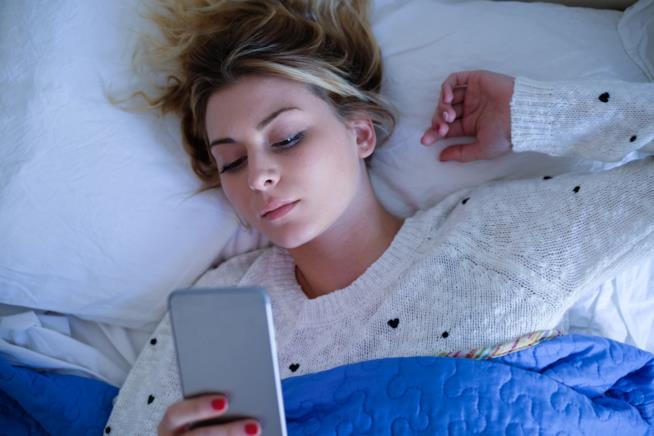 Cos'è e come si tiene sotto controllo la dipendenza da smartphone. Una ragazza che tiene in mano il cellulare.