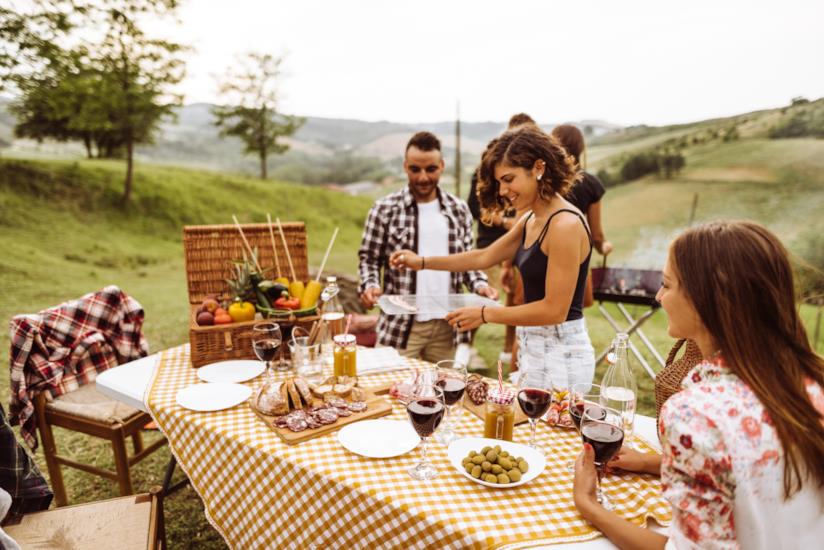 Barbecue a Ferragosto, idee per tutti i gusti Ragazzi a tavola che preparano un barbecue
