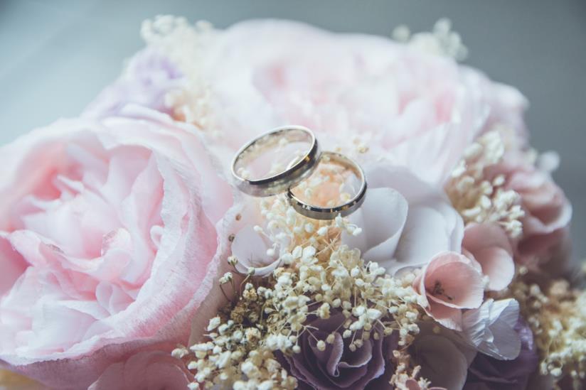 Fiori e fedi nuziali Bouquet di peonie e fedi nuziali per il matrimonio