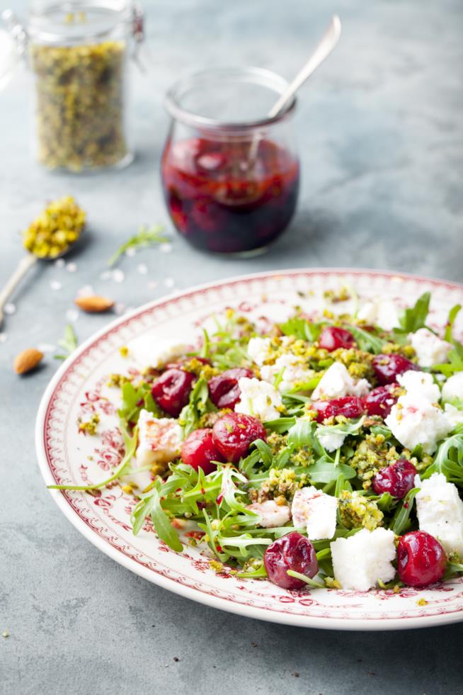 Insalata con rucola, ciliegie e formaggio di capra e piastacchio tritato Insalata con rucola, ciliegie e formaggio di capra e piastacchio