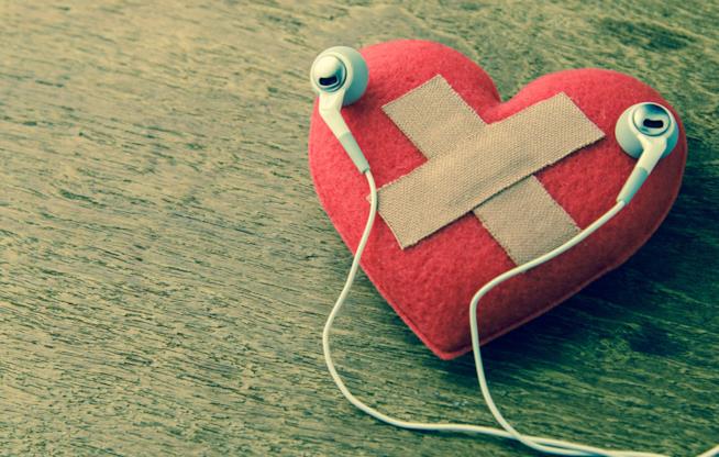 Una ragazza spezza un cuore di carta Il primo piano di un cuore di carta spezzato da una ragazza