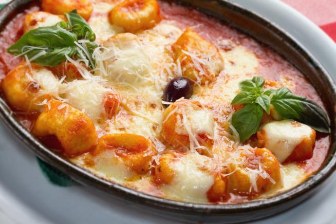 Gnocchi con pomdoro e mozzarella: la ricetta Primo piano di tegame con gnocchi di patate, passata di pomodoro, mozzarella e basilico