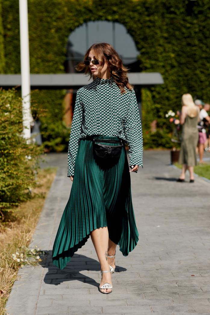 Outfit con marsupio in pelle nero Gonna lunga verde smeraldo con blusa e belt bag in pelle nera