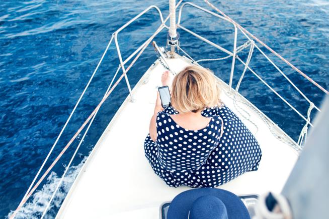 Gli italiani e le app di viaggi Donna che consulta lo smartphone