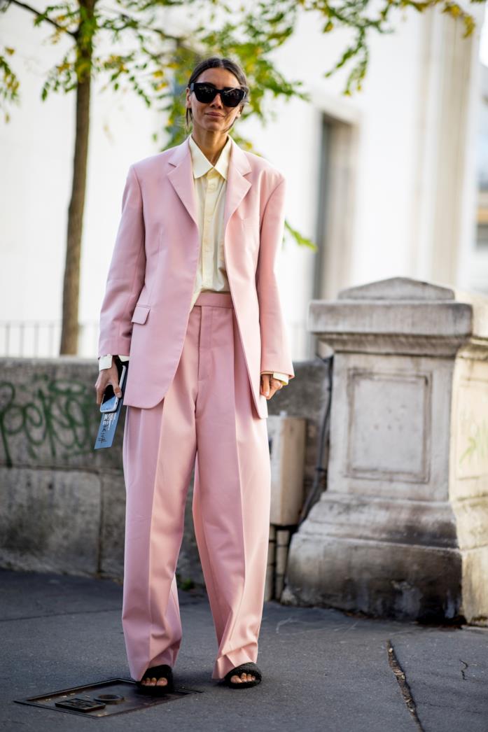 Un completo rosa abbinato a ciabatte rasoterra e camicia beige Completo giacca-pantalone indossato con sandali rasoterra