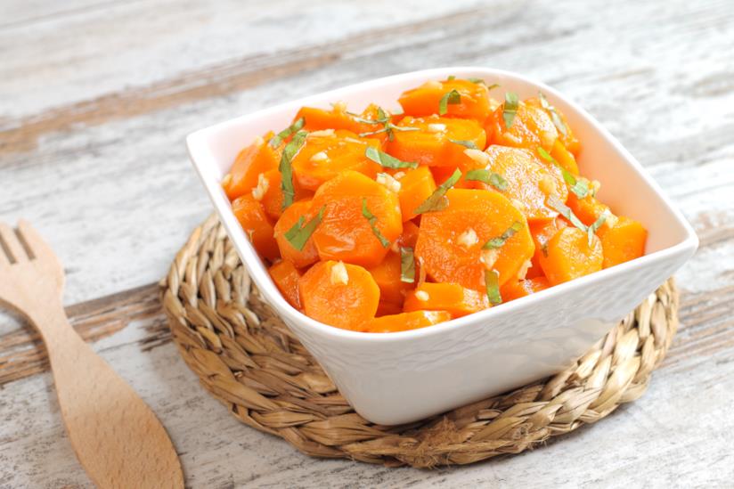 Carote marinate: la ricetta Tegame quadrato di porcellana su sottopentola di paglia intrecciato con carote, aglio e prezzemolo