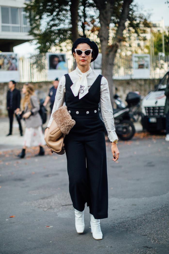 Tuta lunga abbinata a camicia con il fiocco e stivali bianchi Jumpsuit a tinta unita indossata con camicia e ankle boots bianchi