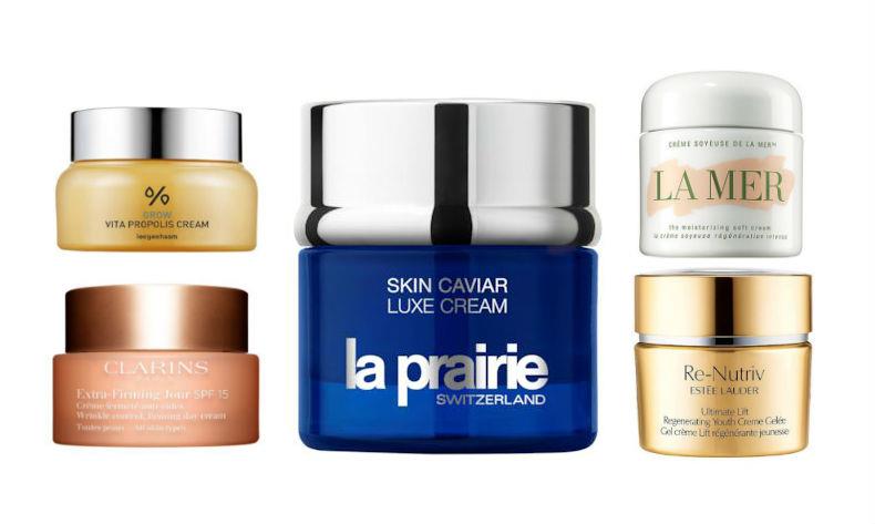 Le migliori creme viso idratanti e rassodanti del 2018: i trattamenti must have Donna che applica crema viso allo specchio