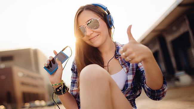 Ragazza ascolta musica su iPhone Una ragazza ascolta della musica sul suo iPhone