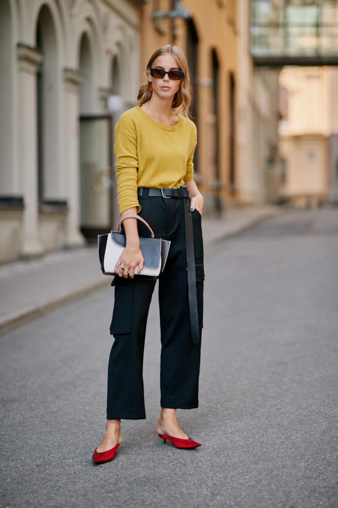 Pantaloni a vita alta indossati con pullover e mules Pantaloni a vita alta abbinati a pullover e mules con tacco mini