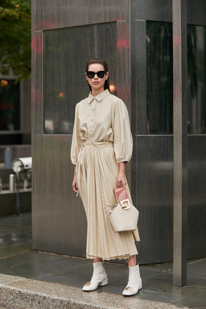 Maxi dress plissettato indossato con stivaletti e handbag coordinata Maxi dress plissettato abbinato a stivaletti e handbag coordinata