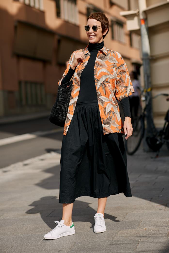 Sneakers total white abbinate a un vestito nero Sneakers bianche indossate con maxi dress nero