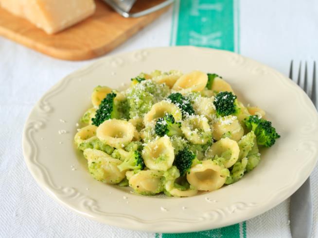 Orecchiette con cime di rapa: la ricetta Piatto bianco di ceramica con all'interno orecchiette, cime di rapa, e formaggio grattugiato
