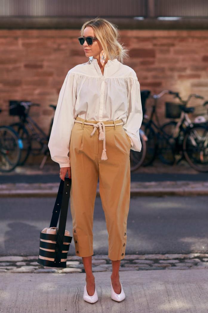 Pantaloni cropped a vita alti indossati con la camicia bianca Camicia, pantaloni bianchi, décolleté e secchiello in pelle