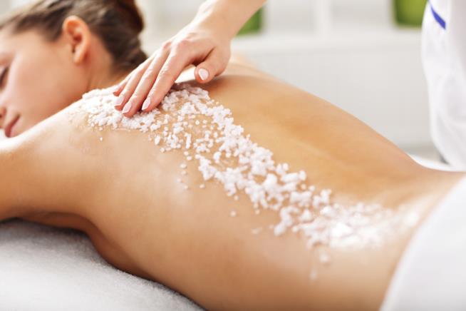 Lo scrub è un trattamento esfoliante per viso e corpo Una donna si sottopone allo scrub corpo