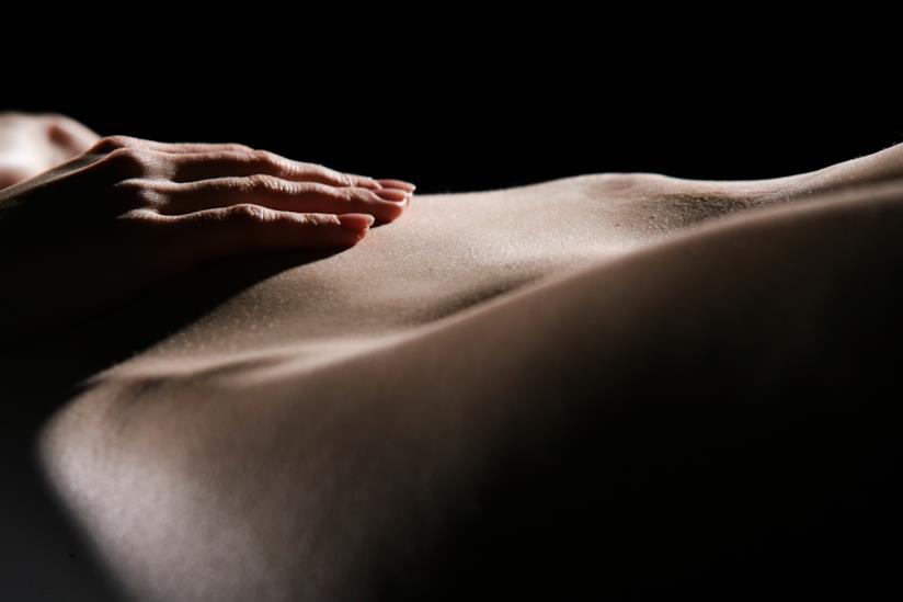 La guida per l'uso degli oli profumati essenziali per un massaggio erotico e sensuale Coppia distesa sul letto