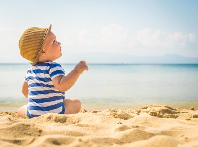 I consigli per un’estate serena col neonato Bambino al mare in spiaggia