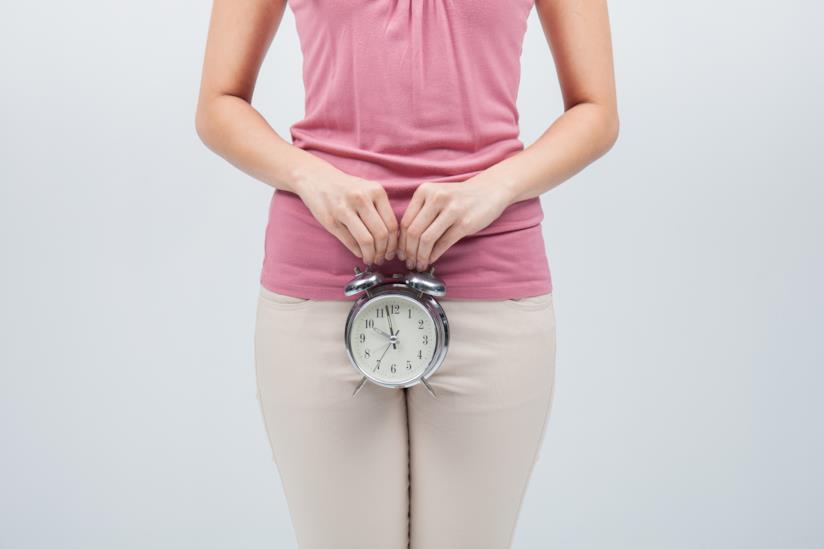 Tutto sulla Proposta di Legge sul congedo mestruale Orologio sveglia in mano di donna