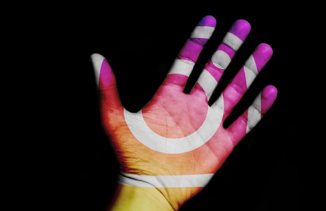 Ecco cos'è e come funziona Donazione: l'adesivo Instagram per fare beneficenza. Una mano con i colori e il logo di Instagram.
