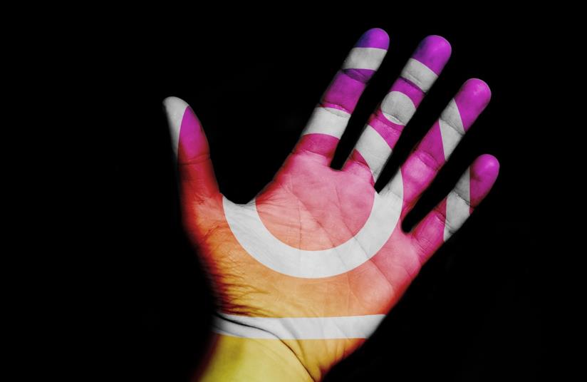 Ecco cos'è e come funziona Donazione: l'adesivo Instagram per fare beneficenza. Una mano con i colori e il logo di Instagram.