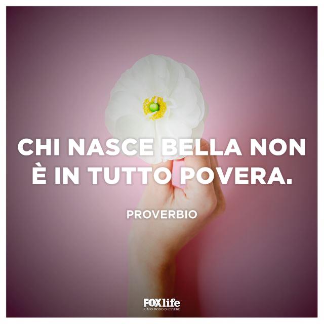 Proverbio sulle donne Mano di donna che tiene un fiore