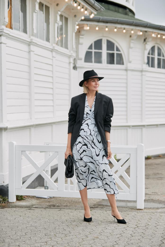 Blazer oversize indossato con abito midi stampato e mules con tacco sottile Blazer oversize abbinato a abito midi stampato e mules con tacco sottile