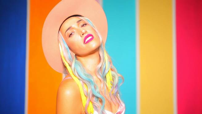 Nina Zilli annuncia le nuove date del tour Nina Zilli con un cappello e i capelli colorati, davanti a uno sfondo colorato