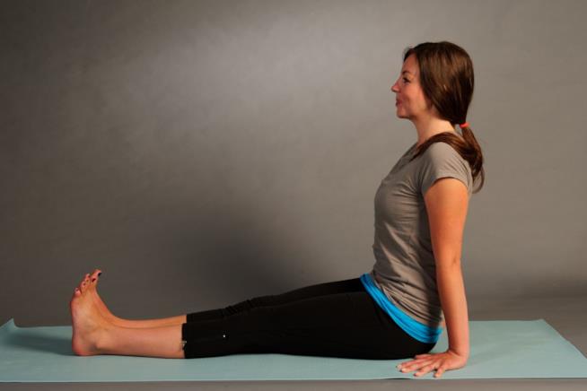 La posizione del bastone Donna che esegue la dandasana