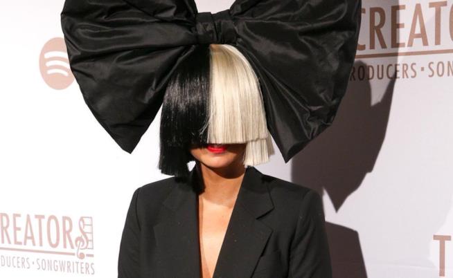Sia sfoggia la sua iconica parrucca Sia in primo piano col volto coperto da una parrucca