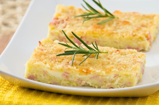 gateau di patate: la ricetta Due fette di gateau di patate con prosciutto cotto e provola con rametto di rosmarino