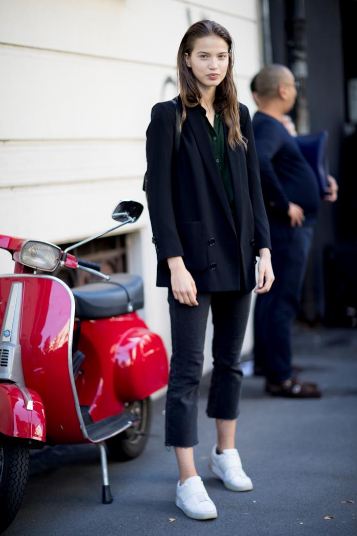 Blazer e jeans neri abbinati a sneakers candide Blazer nero, jeans sfilacciati e sneakers