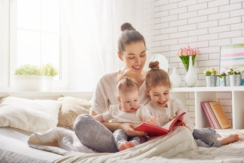 Una mamma che legge con i bambini Una madre legge a letto con i figli