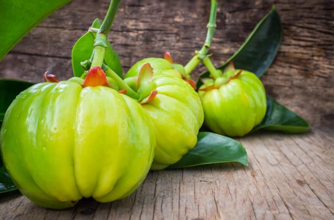 La Garcinia Cambogia ha effetti dimagranti Il frutto posato su una superficie di legno