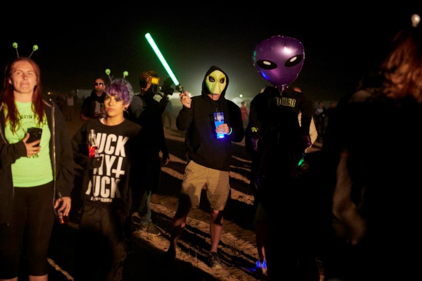 Com'è finito il raid dell'Area 51? Arresti, scuse e i MEME sui social Una foto di spalle di un partecipante al raid dell'Area 51, con un alieno gonfiabile in braccio