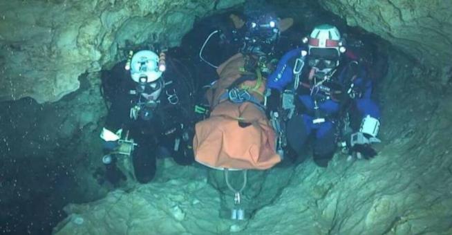 Il salvataggio dei ragazzi nella grotta in Thailandia è finito bene Soccorritori bardati portano fuori dalla grotta un bambino in barella