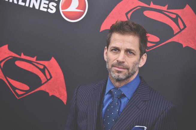 Batman e Superman rimangono soltanto ombre per Zack Snyder Mezzobusto di Zack Snyder su tabellone pubblicitario nero con il simbolo di Batman v Superman