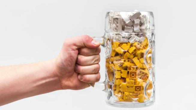 Apriranno nel 2018 i primi bar fatti di LEGO Primo piano di una mano che impugna un boccale di birra contenente mattoncini LEGO