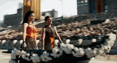 The Hunger Games Peeta e Katniss sul carro mentre i vestiti bruciano