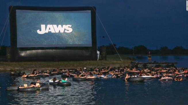 Vedere lo Squalo di Spielberg a mollo in una ciambella Il parco acquatico-cinema in Texas