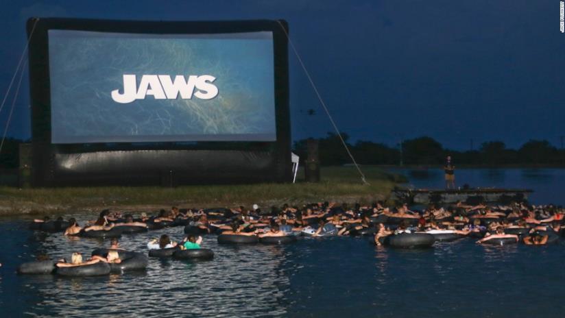 Vedere lo Squalo di Spielberg a mollo in una ciambella Il parco acquatico-cinema in Texas
