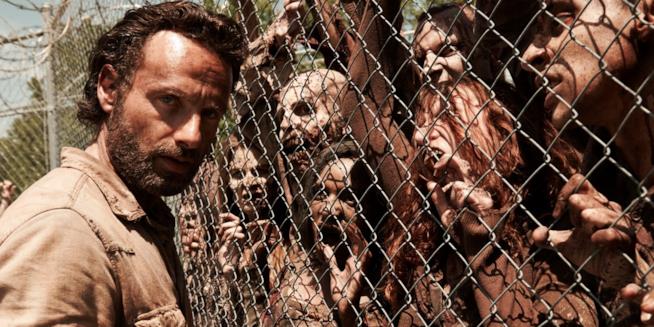 Rick Grimes separato dagli zombie da una rete Una rete divide Rick Grimes da un gruppo di zombie