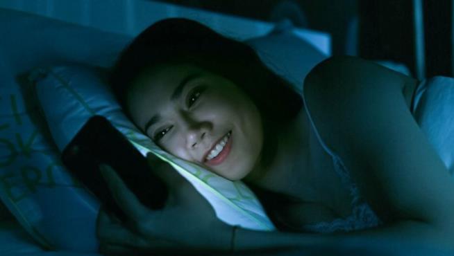 Luce blu, ecco perché è così dannosa per la nostra vista Una giovane utilizza lo smartphone al buio