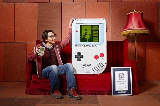 Costruito il Game Boy più grande del mondo, ed è subito record Ilhan Ünal posa con il suo gigantesco Game Boy