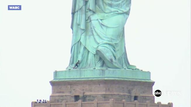 Donna cerca di scalare la Statua della Libert