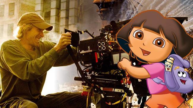 Michael Bay e la produzione di Dora in live-action Michael Bay dietro la telecamera e Dora davanti sorridente a cartone animato