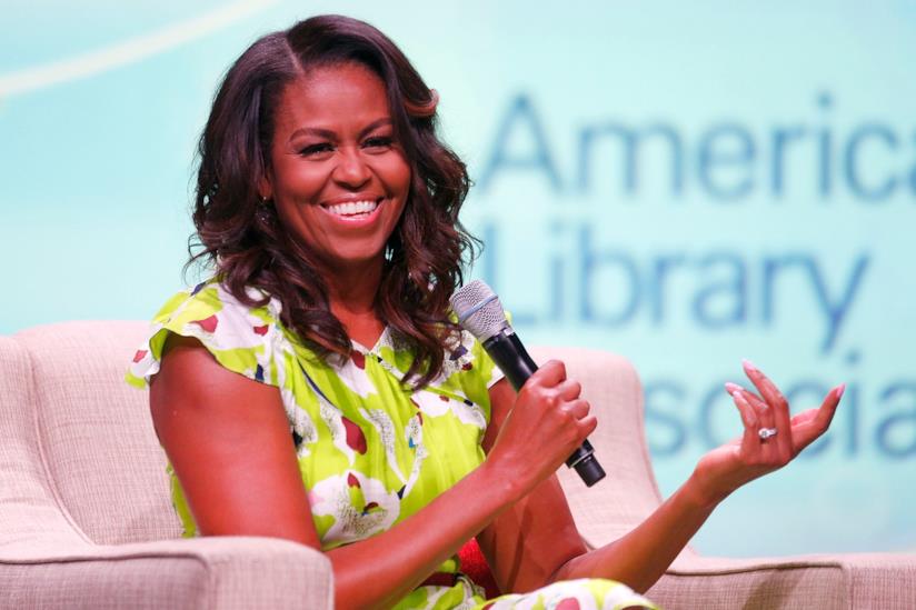Michelle Obama vince il Grammy Award per l'audiolibro di Becoming Michelle sorride con il microfono in mano