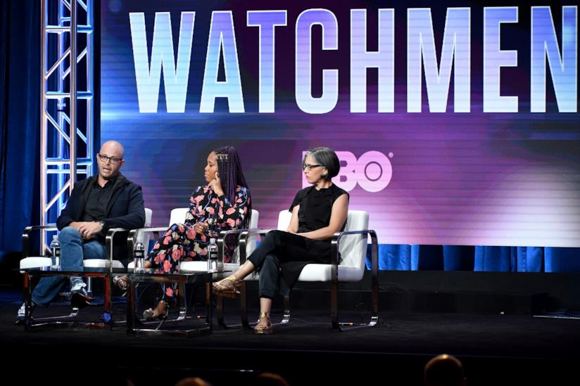 Damon Lindelof viene intervistato ai TCA riguardo a Watchmen, la serie TV Damon Lindelof, Regina King e Nicole Kassell sul palco dei TCA con la scritta Watchmen sullo schermo
