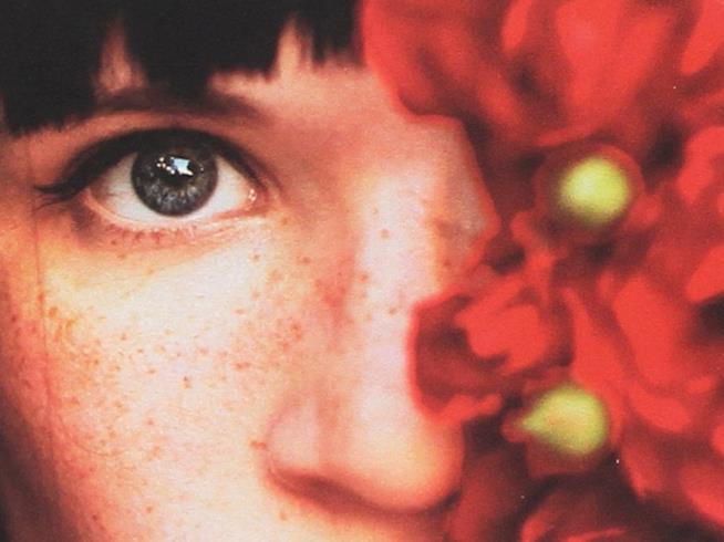 La recensione di Quello che i tuoi occhi nascondono Primo piano di un occhio azzurro e un fiore rosso
