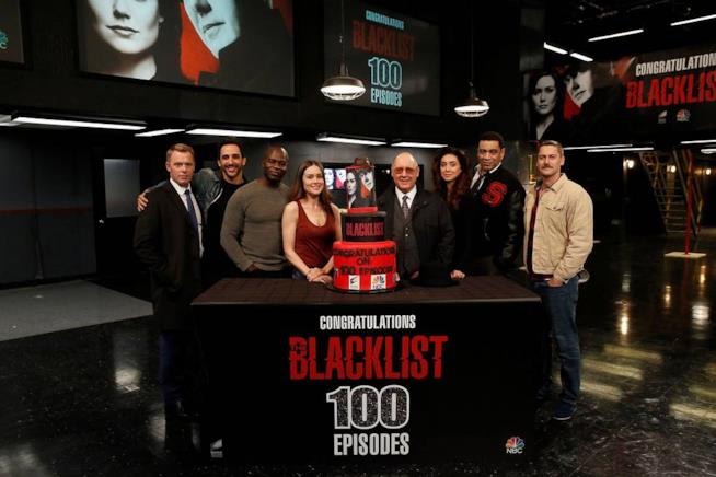 L'intera squadra di The Blacklist ha festeggiato i primi 100 episodi della serie I protagonisti della serie TV dietro la torta per i primi 100 episodi